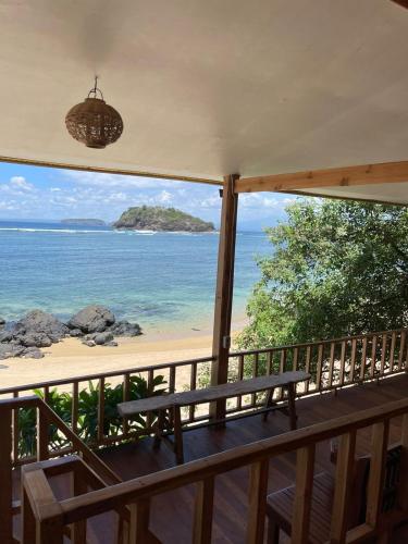 a balcony with a view of the beach and the ocean at Kertasari Golden House Homestay in Pulau Sarang
