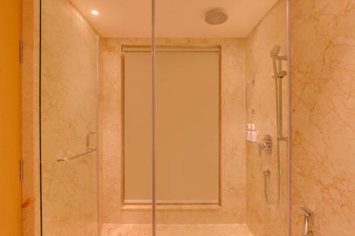 a shower with a glass door in a bathroom at Keys Prima by Lemon Tree Hotels, Kota, Rajasthan in Kota