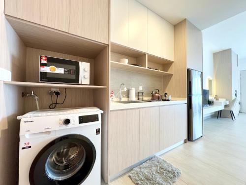 a laundry room with a washer and a kitchen at Sunsuria Forum SOHO & Residence Suites Setia Alam by MOKA in Shah Alam