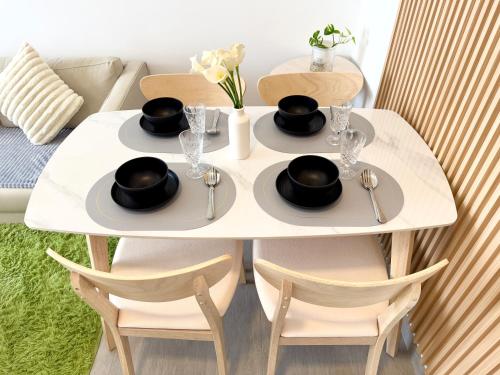 a white table with two plates of food on it at Sunsuria Forum SOHO & Residence Suites Setia Alam by MOKA in Shah Alam