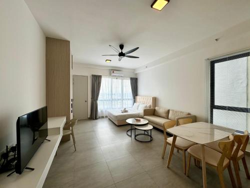 a living room with a couch and a tv and a table at Sunsuria Forum SOHO & Residence Suites Setia Alam by MOKA in Shah Alam