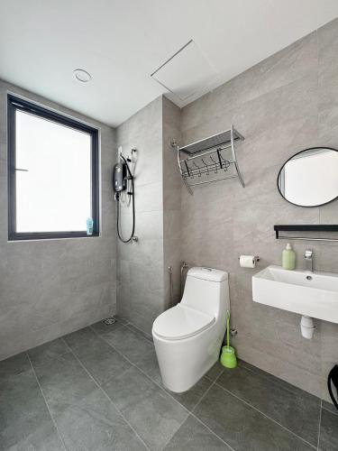 a bathroom with a toilet and a sink and a mirror at Sunsuria Forum SOHO & Residence Suites Setia Alam by MOKA in Shah Alam