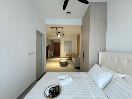 a bedroom with a white bed with a purse on it at Sunsuria Forum SOHO & Residence Suites Setia Alam by MOKA in Shah Alam