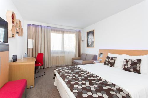 a hotel room with a large bed and a desk at Novotel Warszawa Airport in Warsaw