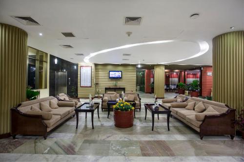 a lobby with couches and tables and a television at Rose View Hotel in Sylhet