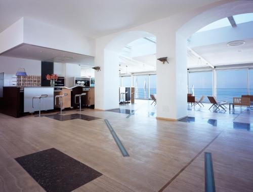 an open room with a kitchen and a living room with the ocean at Hotel Amyclae in Sperlonga