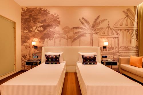 a room with two beds and a couch at Keys Prima by Lemon Tree Hotels, Kota, Rajasthan in Kota