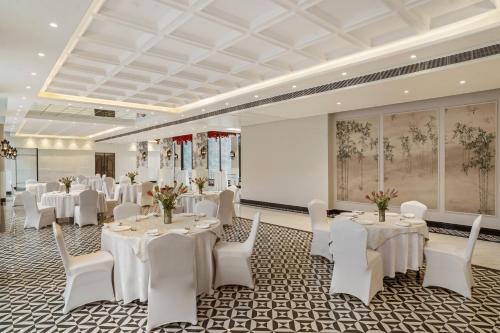 a banquet room with white tables and white chairs at ZANA by the Ganges, Tapovan, Rishikesh in Rishīkesh
