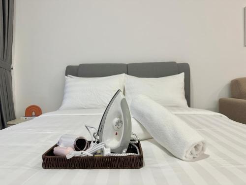 a bed with a tray with a iron on it at Sunsuria Forum SOHO & Residence Suites Setia Alam by MOKA in Shah Alam