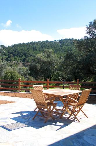 a wooden table and chairs on a patio at Aria Monte Villas in Raches