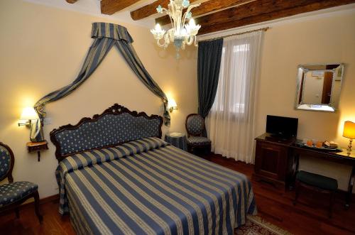 a bedroom with a bed and a desk and a mirror at Hotel Da Bruno in Venice