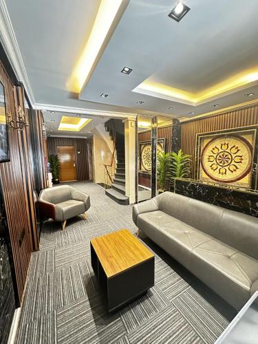 a lobby with a couch and a table and a clock at New Hotel Harbiye in Istanbul