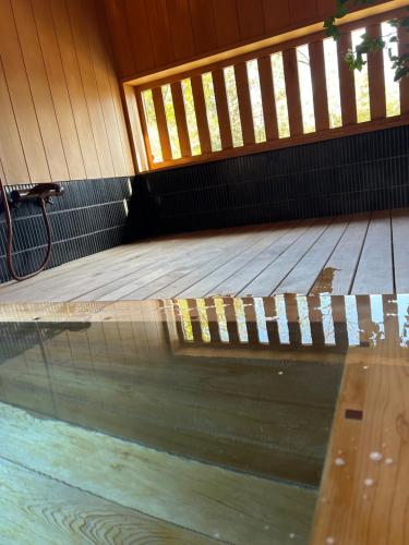 a swimming pool with a wooden floor and a wooden deck at 風の沢 in Kurihara