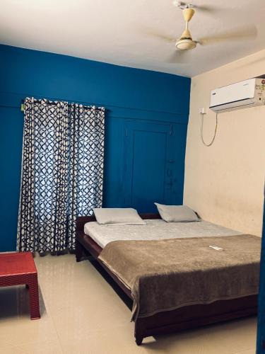 a bedroom with a bed with blue walls and a ceiling at Hello entire villa varkala cliff in Varkala