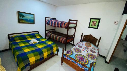 a bedroom with two bunk beds and a chair at Hostal El Mirador in Minca