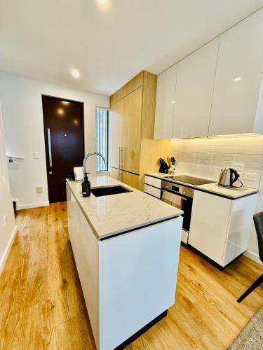a kitchen with white cabinets and a counter top at Stylish 2 bedrooms townhouse in central Wellington with a free car park in Wellington
