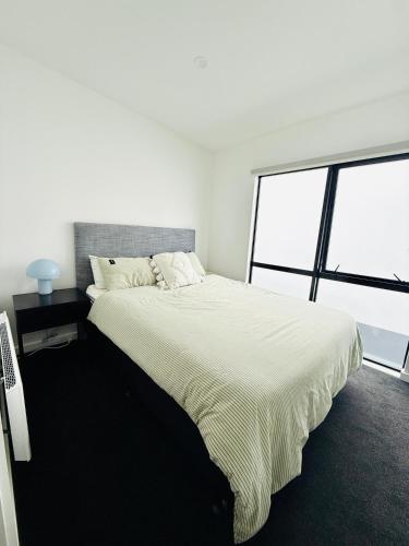 a white bedroom with a large bed and a window at Stylish 2 bedrooms townhouse in central Wellington with a free car park in Wellington