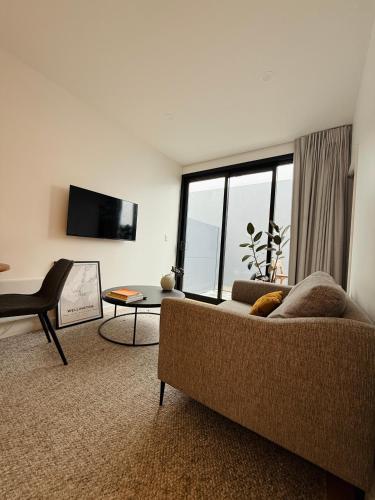 a living room with a couch and a large window at Stylish 2 bedrooms townhouse in central Wellington with a free car park in Wellington
