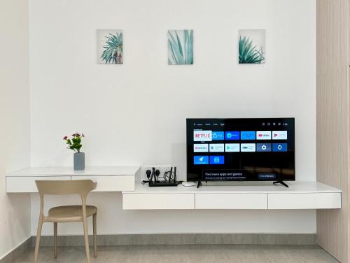a white desk with a television and a chair at Sunsuria Forum SOHO & Residence Suites Setia Alam by MOKA in Shah Alam