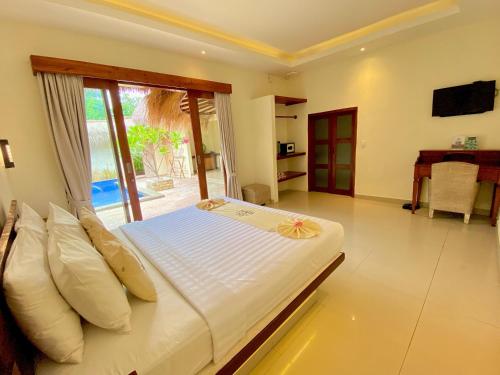 a bedroom with a bed and a sliding glass door at La Bella - Hotel Villa & Spa in Gili Trawangan