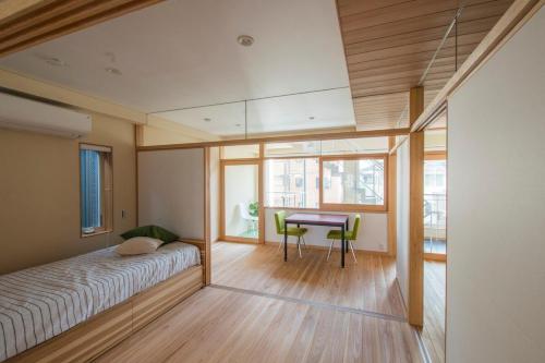 春日井ひろびろ空間の3階建デザイナーズ住宅的一间卧室，配有一张床、一张书桌和一张桌子