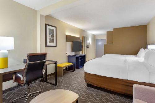 a hotel room with a large bed and a desk at Comfort Suites Hanes Mall in Winston-Salem