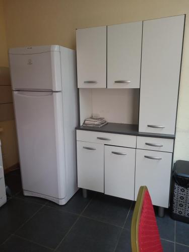 a kitchen with white cabinets and a refrigerator at CHAPELLE ST NICOLAS in Roanne