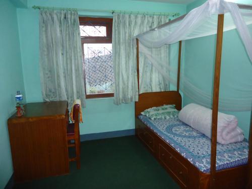 1 dormitorio con cama con dosel y ventana en Sanu House en Pātan