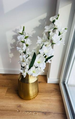 a gold vase with white flowers in a room at Pension Romantica in Rust