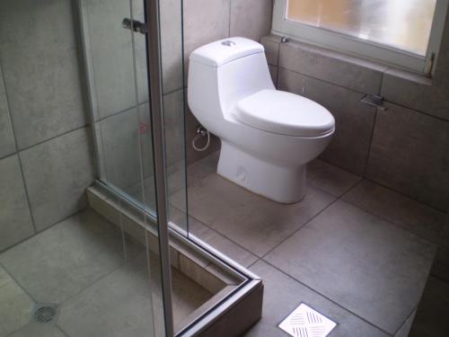 a bathroom with a toilet and a glass shower at Bolivian Rooms & Suites (Zona Sur) in La Paz