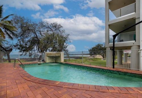 a swimming pool in front of a building at Bargara Beach Bliss in Bargara