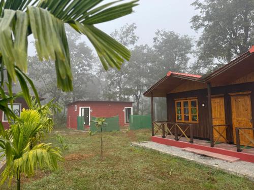a couple of small houses in the forest at Cheetah Farms Jungle Stay in Dandeli