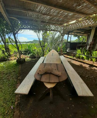 a surfboard sitting on top of a wooden bench at La Table d Alexandre Gîte de charme entre mangrove et mer in Hell-Ville