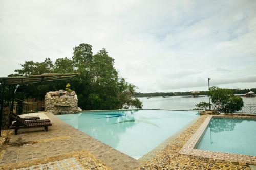 a swimming pool with a view of a body of water at Marina Palawan Boutique Nature Resort in Puerto Princesa City