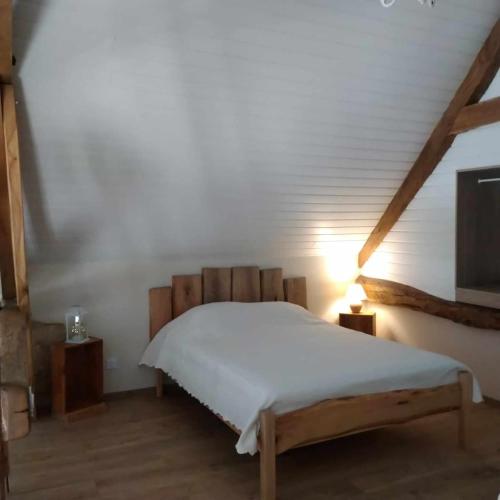 une chambre avec un lit avec un couvre-lit blanc dans l'établissement La Grange du Poussié, à La Salvetat-Peyralès