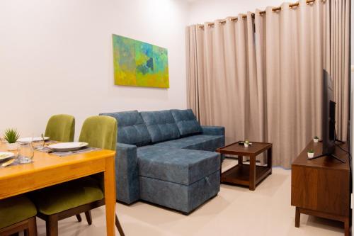 a living room with a blue couch and a table at Urban Oasis, Tri-Zen Luxury Apartment in Central Colombo in Colombo