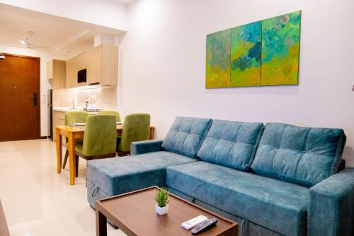 a living room with a blue couch and a table at Urban Oasis, Tri-Zen Luxury Apartment in Central Colombo in Colombo