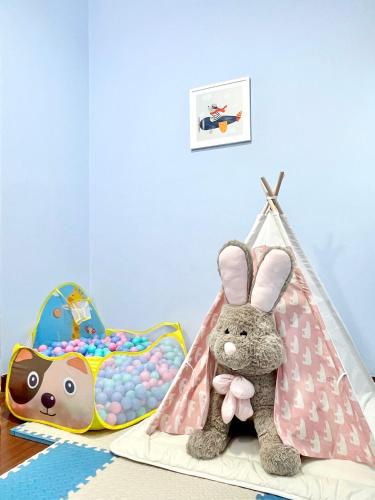 a childs room with a toy tent and a stuffed rabbit at Sunsuria Forum SOHO & Residence Suites Setia Alam by MOKA in Shah Alam
