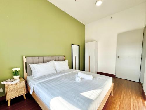 a bedroom with a large bed with a green wall at Sunsuria Forum SOHO & Residence Suites Setia Alam by MOKA in Shah Alam