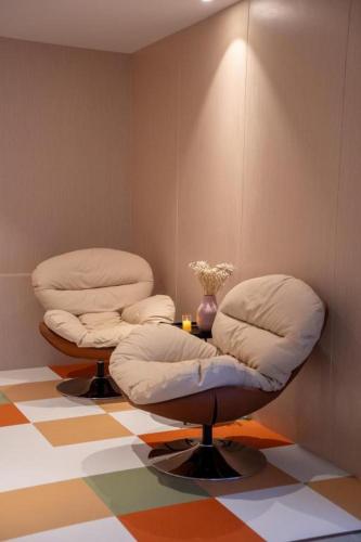 two ottoman chairs sitting on a colorful floor at 777Bliss Hometel in Nakhon Phanom