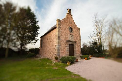 a brick church with a cross on top of it at Château Hôtel Du Colombier in Saint Malo