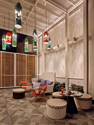 a lobby with chairs and tables and pendant lights at The Park Bangalore, MG Road in Bengaluru