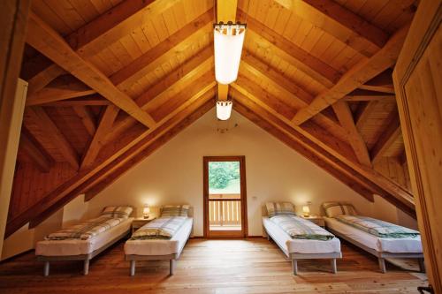 a bedroom with four beds in a room with wooden ceilings at Albergo Diffuso Tolmezzo in Tolmezzo