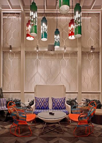 a lobby with chairs and a table and chandeliers at The Park Bangalore, MG Road in Bengaluru