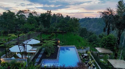 a resort with a swimming pool and a view of a forest at The Hidden Valley in Besakih