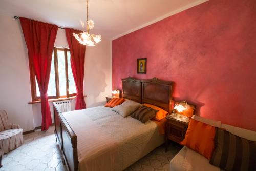sypialnia z łóżkiem i czerwoną ścianą w obiekcie Bed and Breakfast Welcome w mieście Sarzana