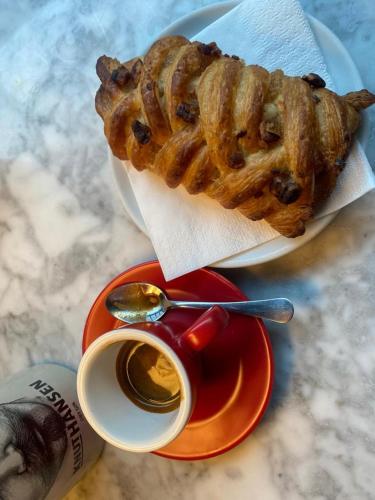 a plate with a pastry and a cup of coffee at La Fiumara - Room with Bathroom in Bitonto
