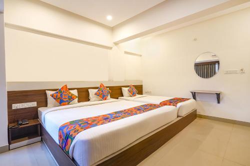 Un dormitorio con una cama grande en una habitación. en FabExpress Royal N Comforts - Nr Shivoham Shiva Temple, en Bangalore