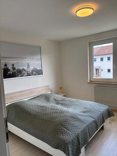 a bedroom with a bed with a picture on the wall at Ferienwohnung im Heiligenberg in Langenburg