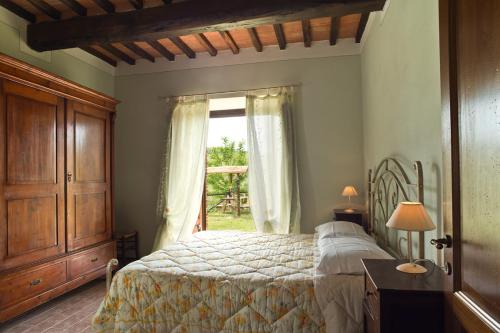 a bedroom with a bed and a window at Agriturismo Podere Campaini in Volterra
